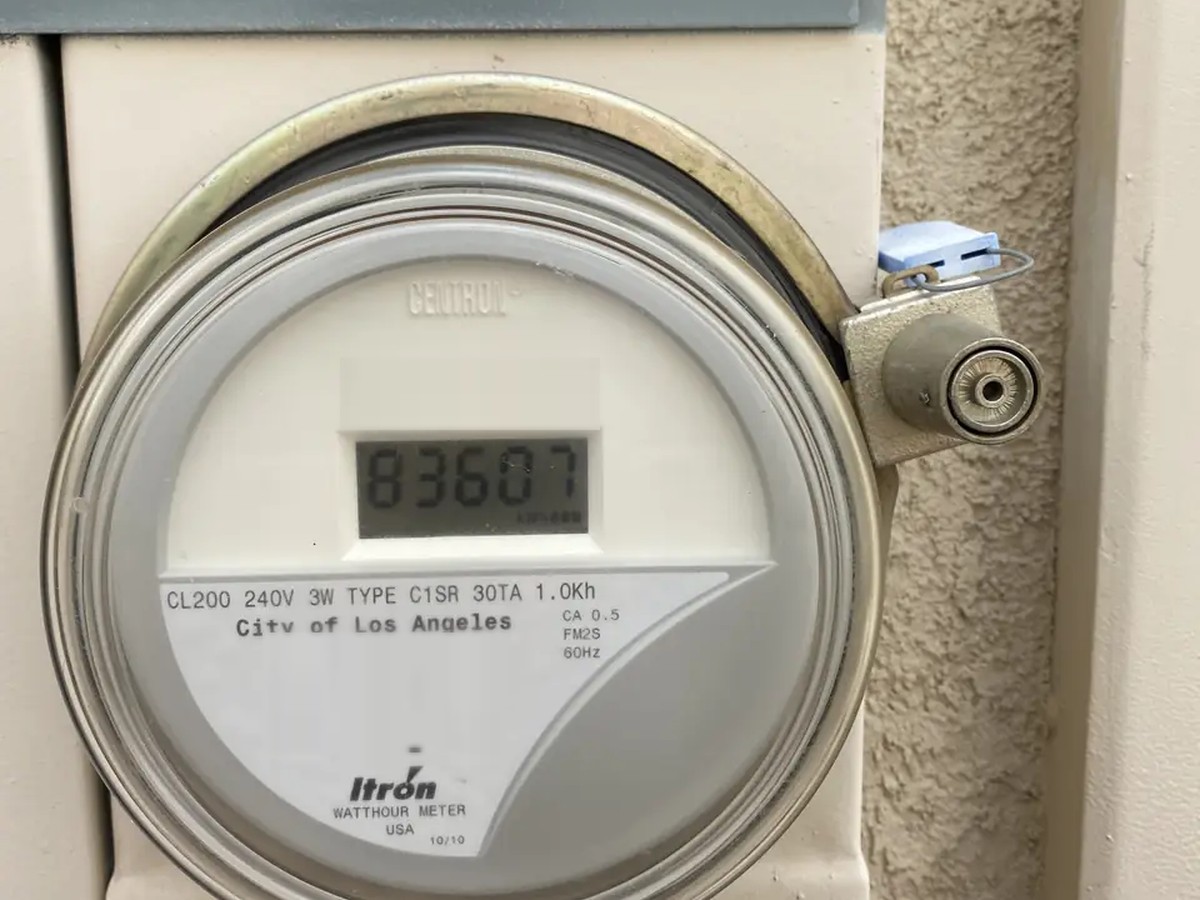 An LADWP watthour meter on an exterior wall, sealed at the socket, below a locked service disconnect