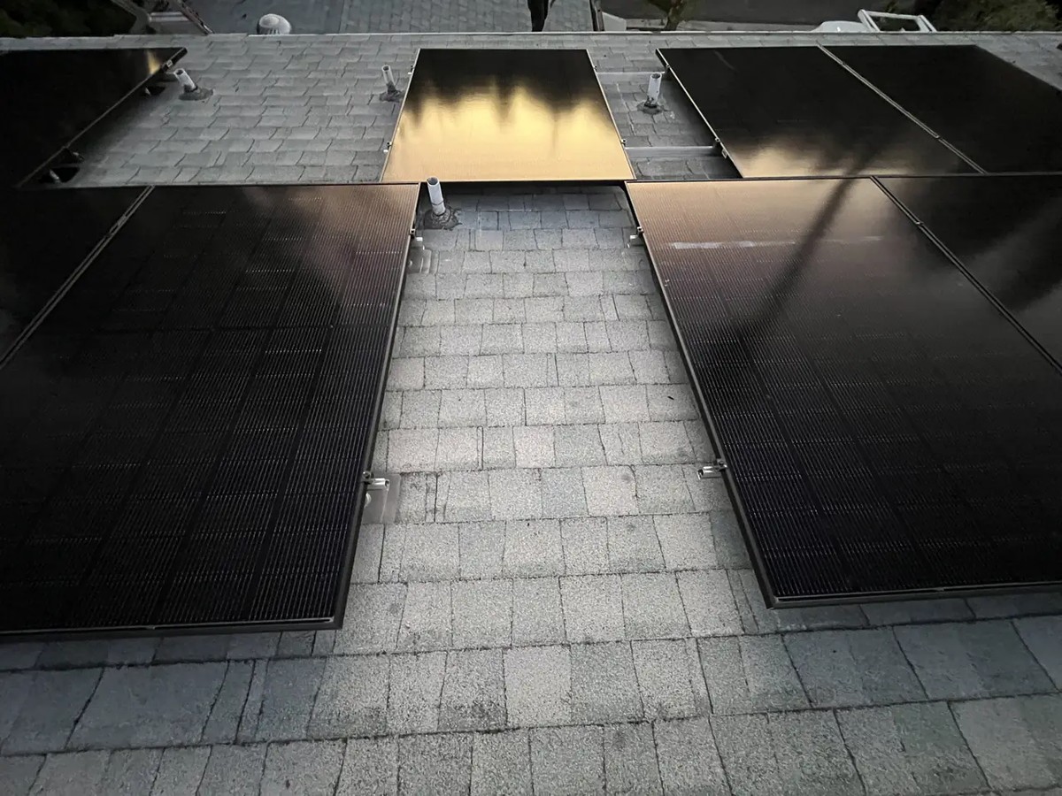 A rooftop array split into two blocks by a clear pathway running from ridge to eave, with a plumbing vent left inside the clear strip