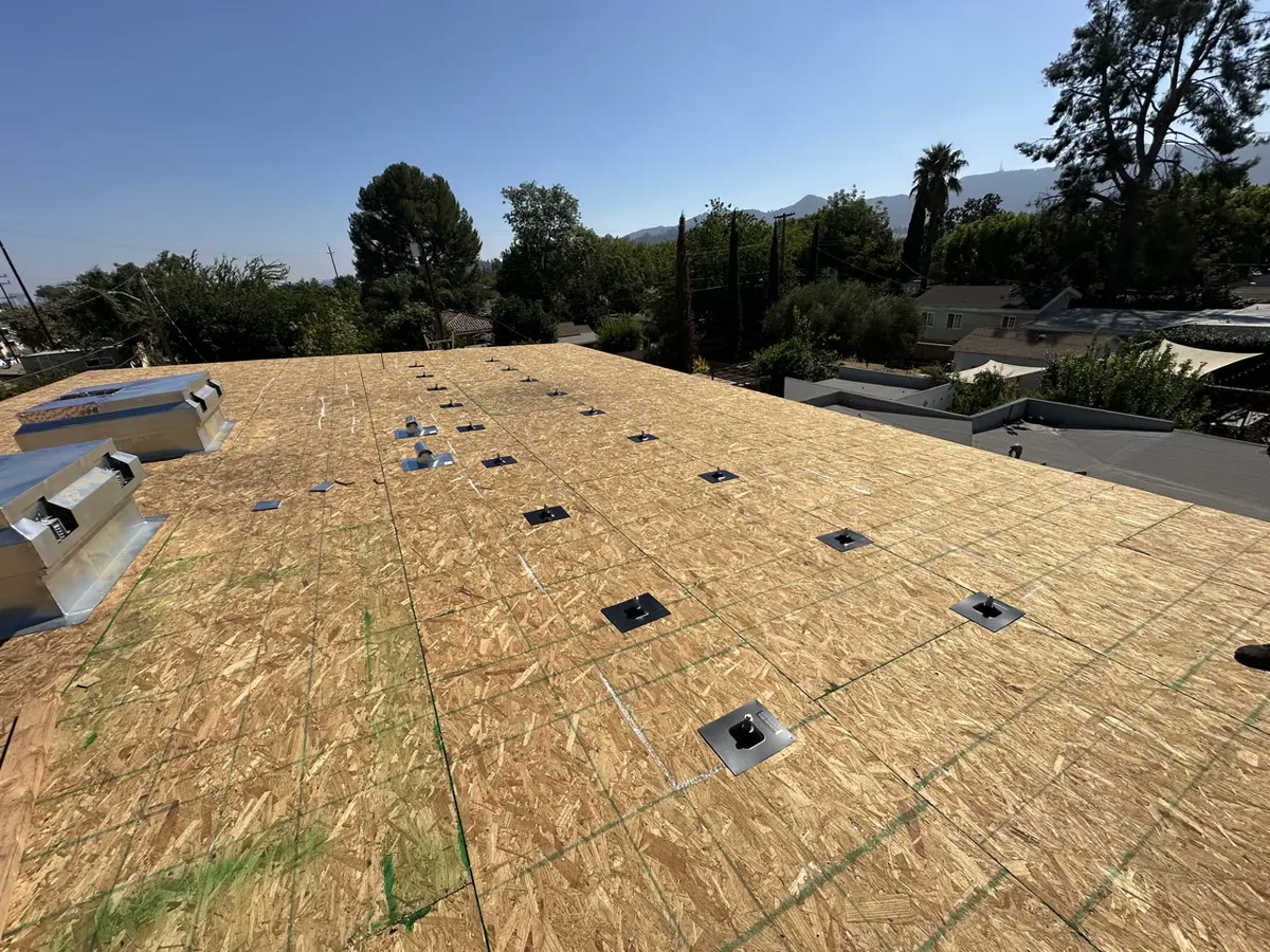 Mount bases set out on an exposed roof deck, following a marked anchor grid