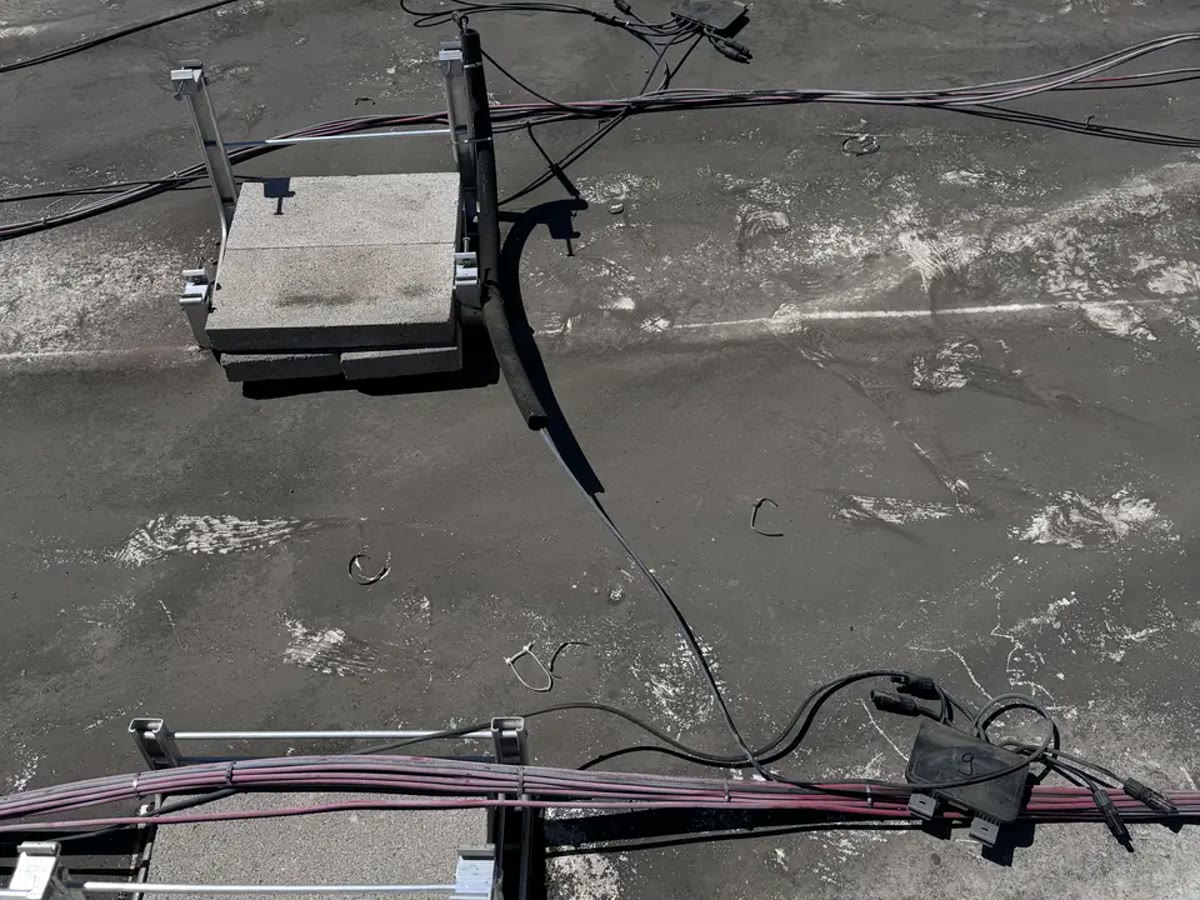 Ballasted racking on a low-slope roof: concrete ballast in trays, no penetrations