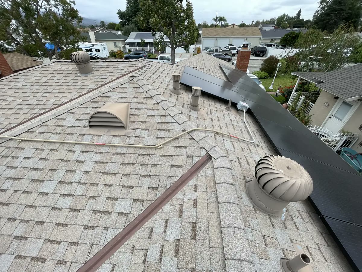 Two turbine ventilators and a dormer vent on a shingle roof, with the solar array running alongside them